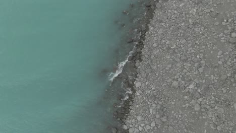 rising up drone shot of lake pukaki showing the beach and the lake