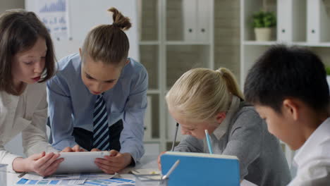 panning of classmates sitting at desk in classroom, doing task in pairs