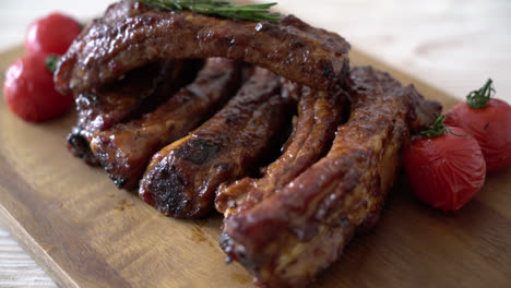 costillas de cerdo asadas a la parrilla sobre tabla de madera