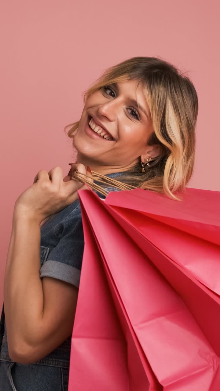 Excited shopaholic transgender woman carrying shopping bags