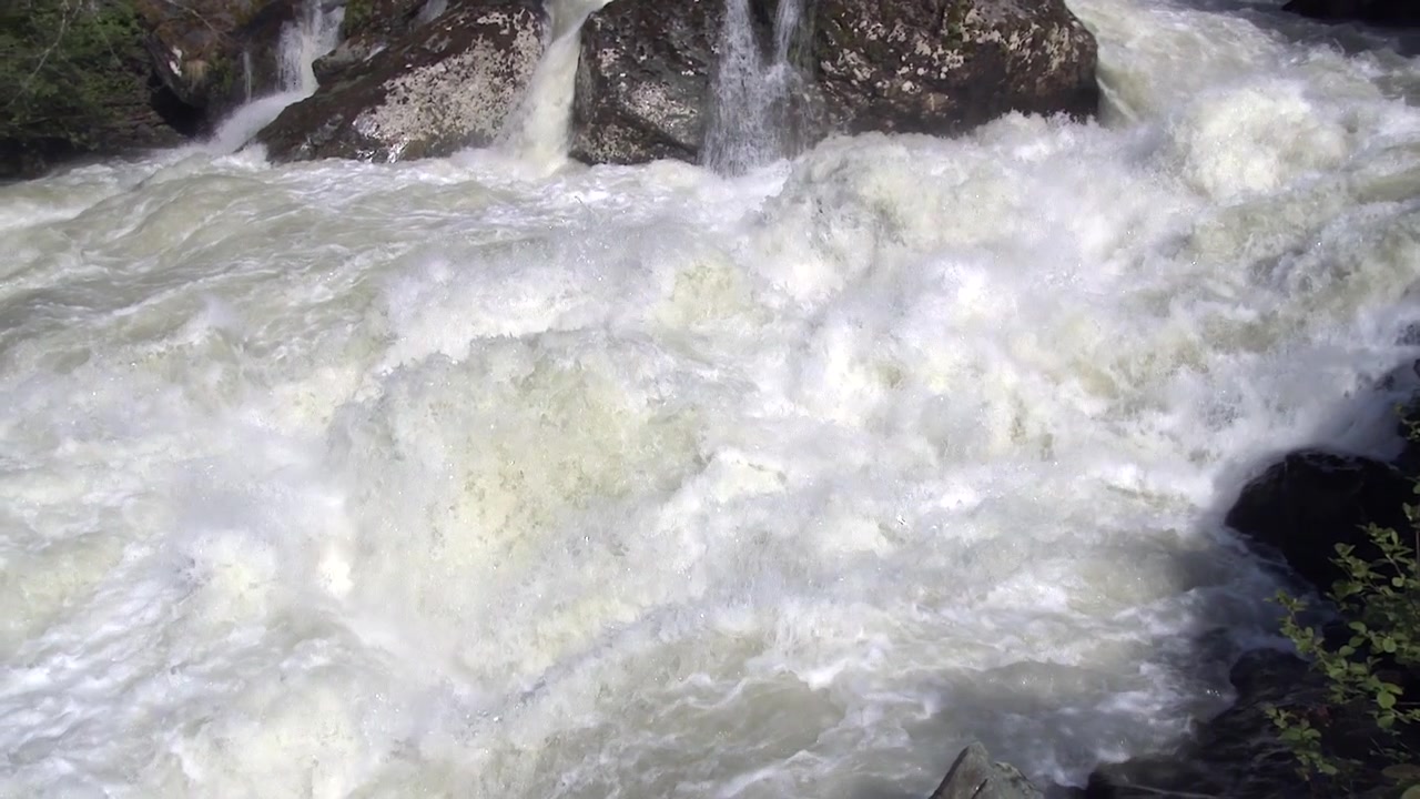 Kraftigt strømmende flodvand, der fosser over klipper