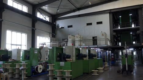sunbeam through electrical manufacturing facility setting industrial electric copper wire spools cable coil manufacturing process precision, automation for components, cables equipment production