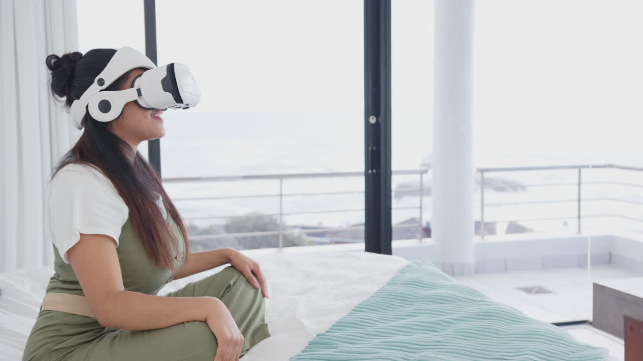Using VR headset, asian woman relaxing on bed in spa setting, enjoying virtual experience, at home