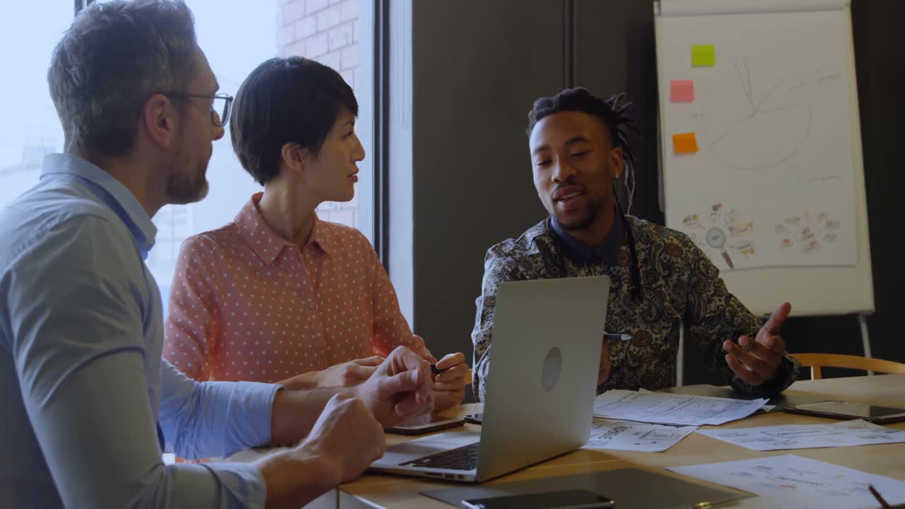 Business executives discussing over laptop in conference room 4k