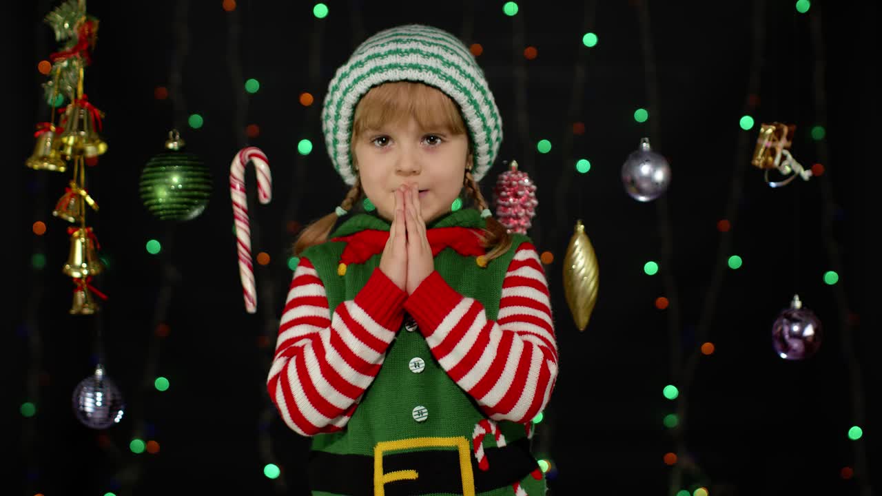 Christmas wish concept. Kid teen girl in Christmas elf Santa helper costume making a wish, prays