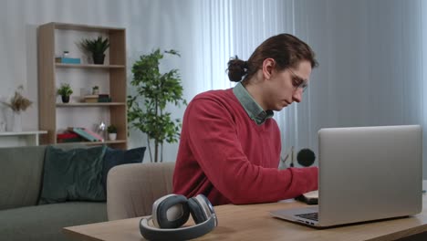 hombre trabajando desde casa en la computadora portátil