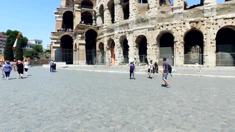 moving pov on pavement near famous colosseum amphitheater in rome, slow motion