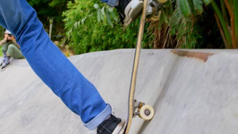 side view of young caucasian man doing skateboarding trick on ramp in skateboard park 4k