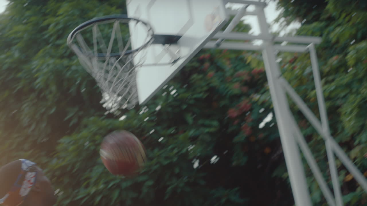 Two Young Men Playing Basketball Outside during Golden Hour