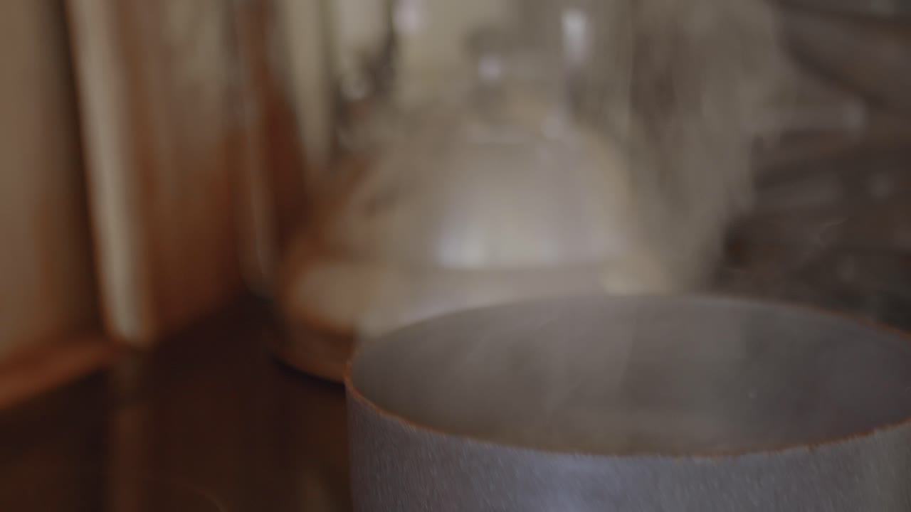 카메라는 수증기를 따라 끓는 물 냄비에 멈춘다.