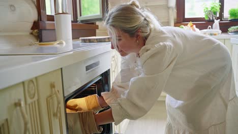 woman taking food out of the oven