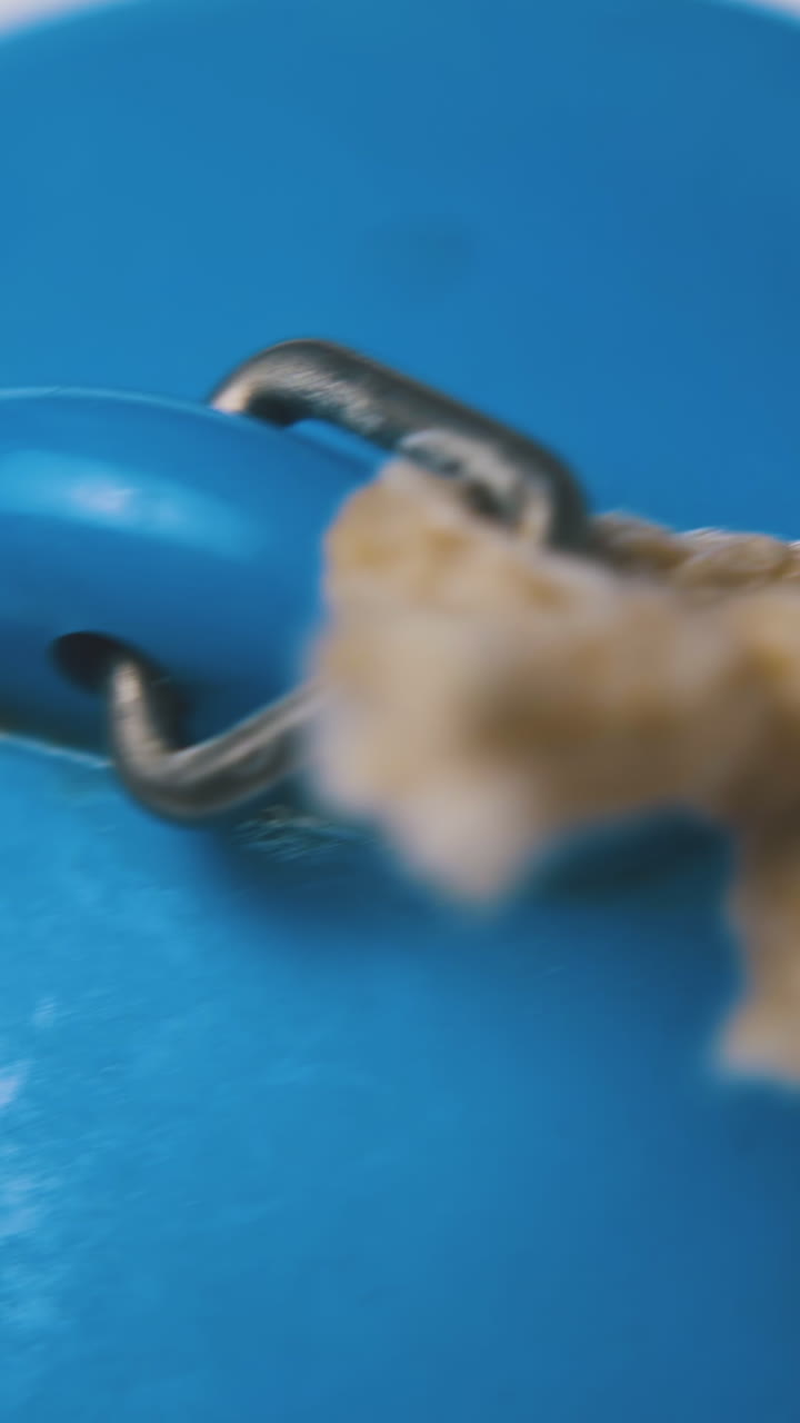 blue rubber basin plug with short rustic rope lies on clean white background extreme close view