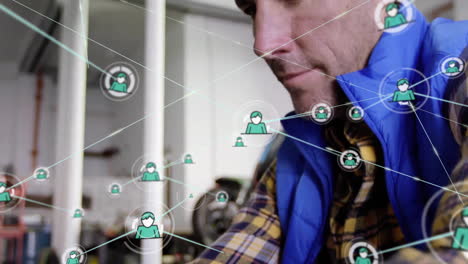 Animation-of-network-of-connections-with-icons-over-caucasian-mechanic-using-smartphone