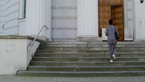 woman walking up steps of a church building