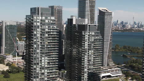glass and concrete skyscrapers of lake ontario are shining above the ground on a sunny day