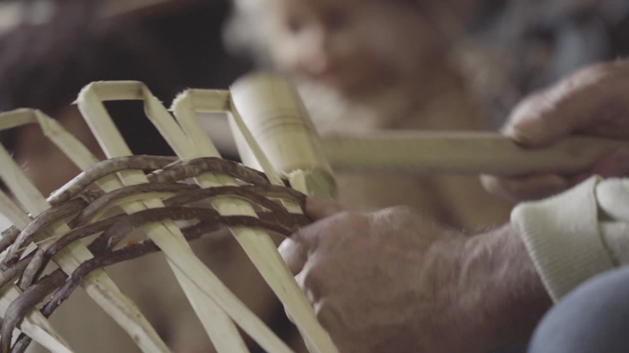 Turkish master weaves baskets from wooden sticks. 4K close-up. Craft concept.