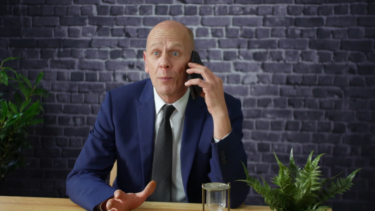En frustreret forretningsmand taler i telefon.