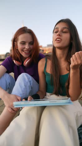 two young women discussing on a tablet