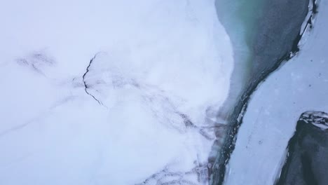 drone rises up over a frozen lake in switzerland