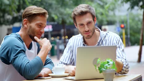 Freunde-Diskutieren-Am-Laptop,-Während-Sie-Im-Café-4K-Kaffee-Trinken