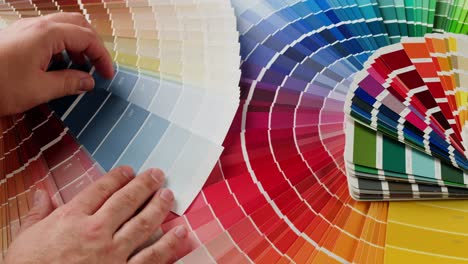 person choosing paint colors from a large color palette.