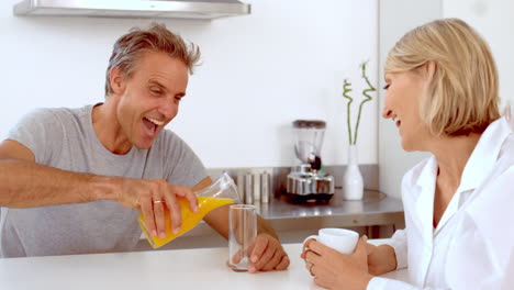 cheerful man pouring orange juice