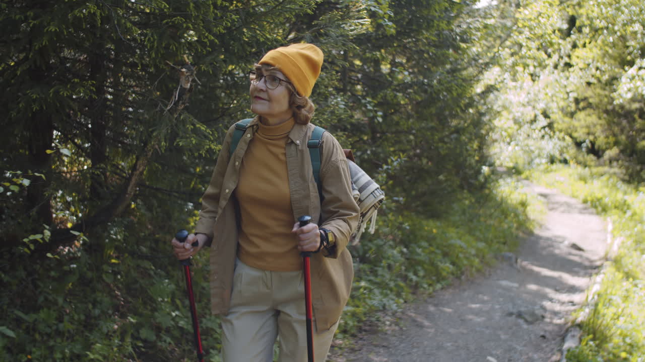 Oudere vrouw wandelt in een bos