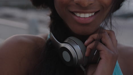 close up portrait of attractive woman holding headphones smiling to camera