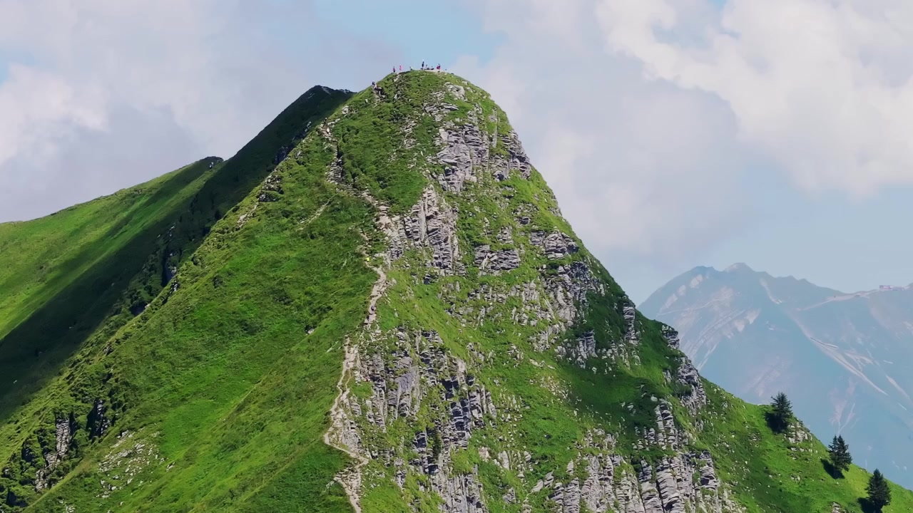 Ripresa aerea mostra escursionisti sulla cima del sentiero Hardergrat, circondati dalle montagne.