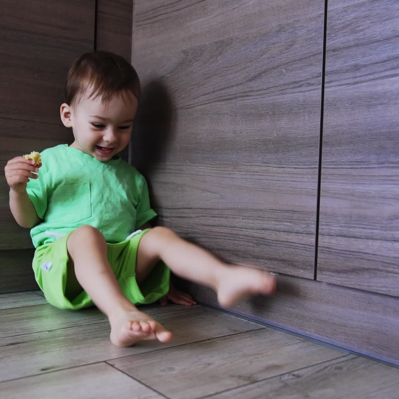 Lovely cute baby boy sitting on the floor. Little kid tries to say something with gestures