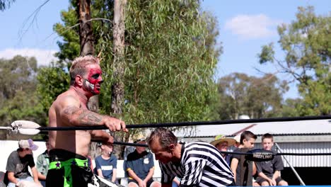 luchador discute con el árbitro durante un evento al aire libre