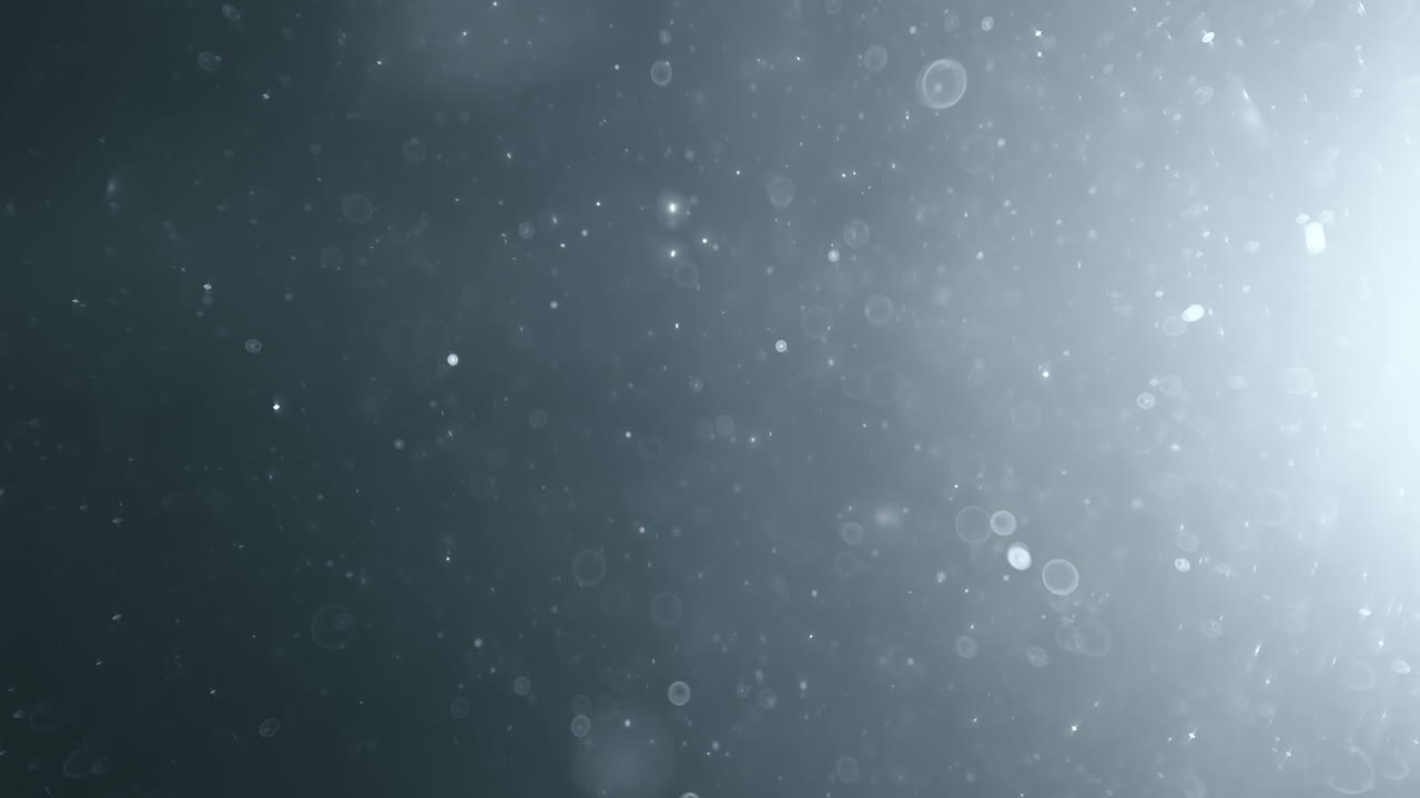 Floating abstract particle bokeh on dark background