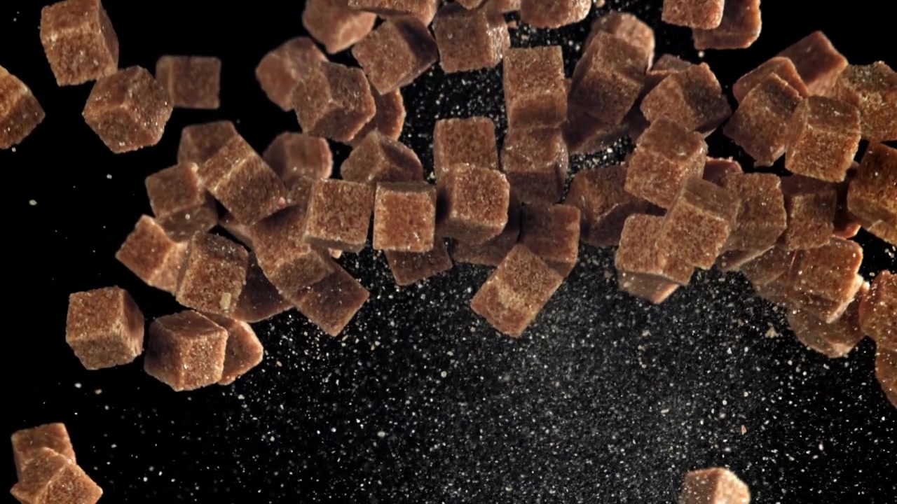 Brown Sugar Cubes Falling in Slow Motion on a Black Background