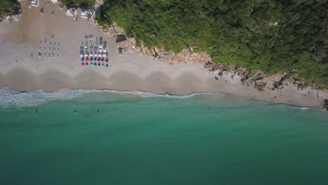 dreamy beach with calm turquoise waves and beach umbrellas on the sand in arraial do cabo, brazil