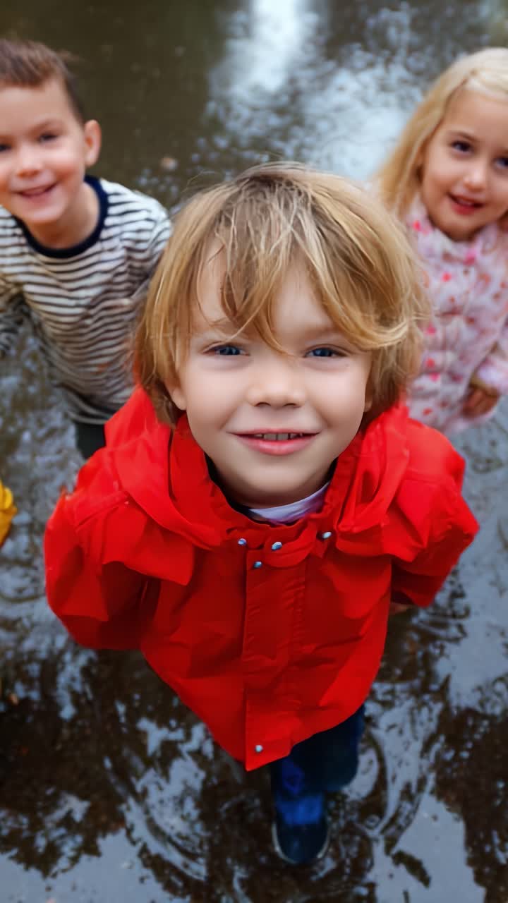 Bambini felici che giocano nell'acqua durante una giornata piovosa, indossando impermeabili colorati, immortalando momenti felici all'aperto nel parco, schizzando e divertendosi insieme