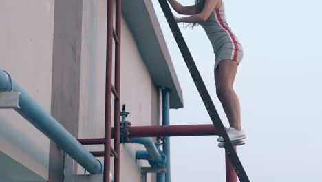 Una-Mujer-Sube-Una-Escalera-De-Metal-Pasando-Por-El-Equipo-De-Servicio-Del-Hotel