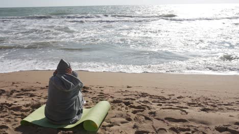 person meditating on a beach