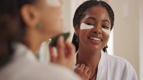woman applying eye patches in the mirror