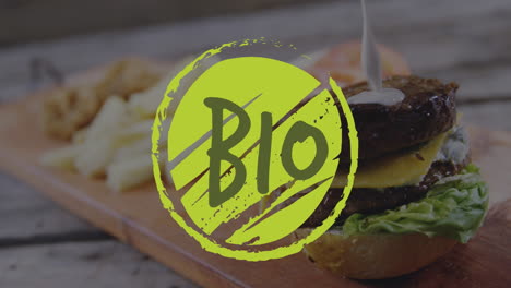 animación del texto biológico en el logotipo verde sobre salsa blanca que se vierte en la hamburguesa con queso vegetariana