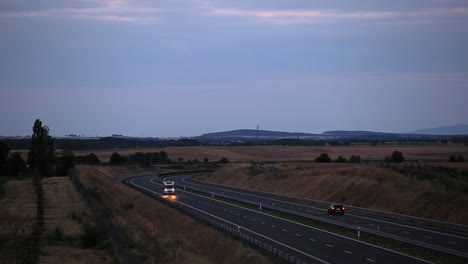 Autocaravana-En-Una-Carretera-Durante-El-Anochecer-Con-Montañas-En-Segundo-Plano.