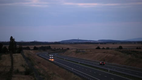 campervan on a highway road during dusk with mountains in background
