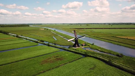 traditional windmill in dutch landscape aerial shot flying backwards