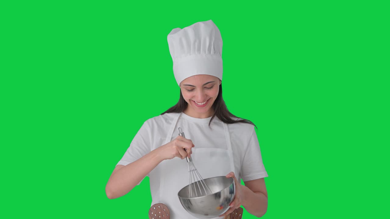 Felice chef professionista indiana che prepara cibo. Schermo verde