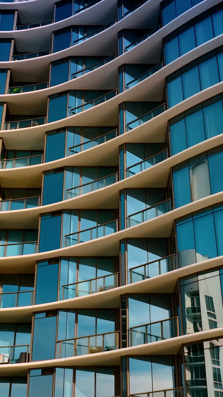 Beautiful facade of multi-storied apartment block with mirror windows. Low angle view on the building in Miami, Florida, USA. Vertical video