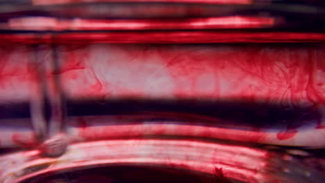 macro of test tube with blood. stirring red liquid in glassware with pipette