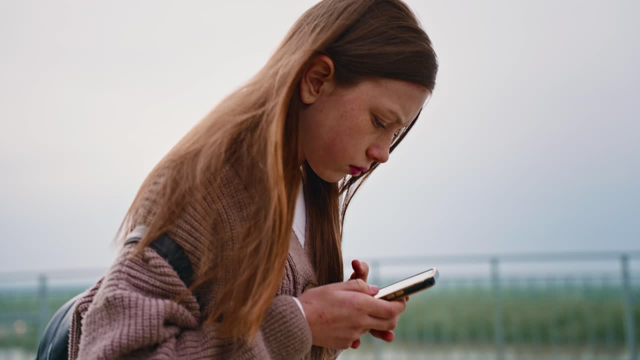 밖에서 스마트폰을 사용하는 십대 소녀