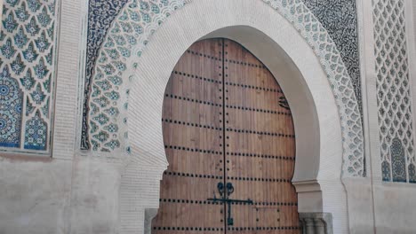 ancient moroccan architecture with ornate tile designs and a wooden gate in meknes