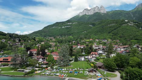 talloires beach at turquoise lake annecy in french alps - aerial pedestal up