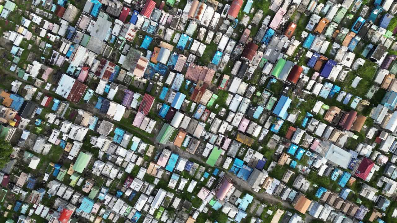 Top-down aerial view of a densely packed cemetery with colorful tombs in Dili