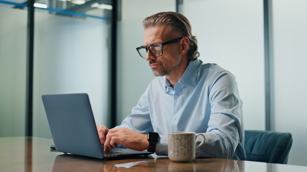 Focused businessman texting laptop at office closeup. Eyeglasses ceo man working